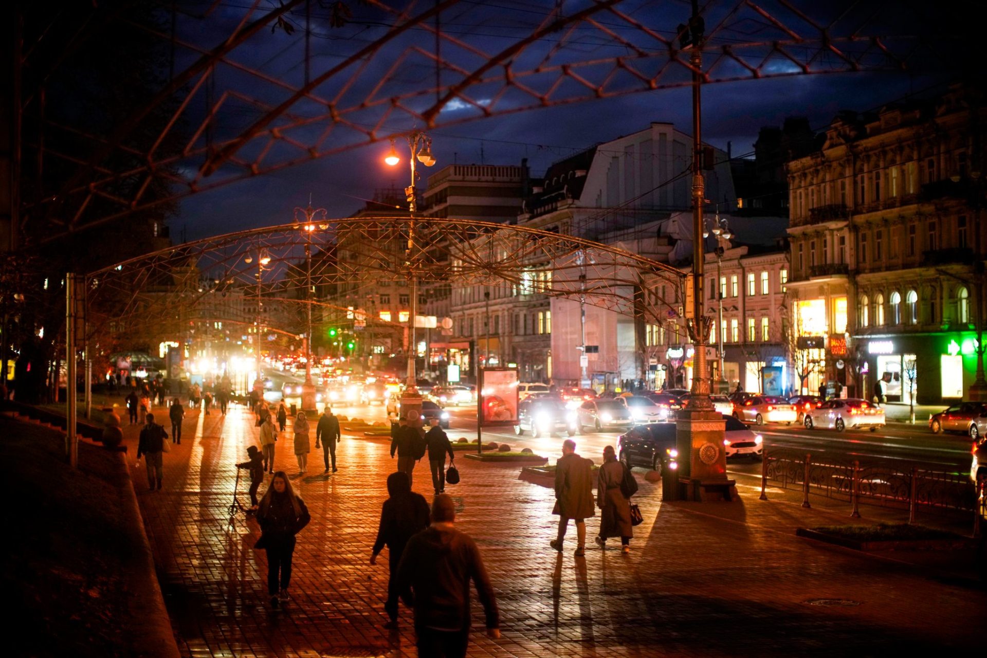 Pasanten gehen in der Abenddämmerung die Chreschtschatyk-Straße in der Innenstadt entlang.