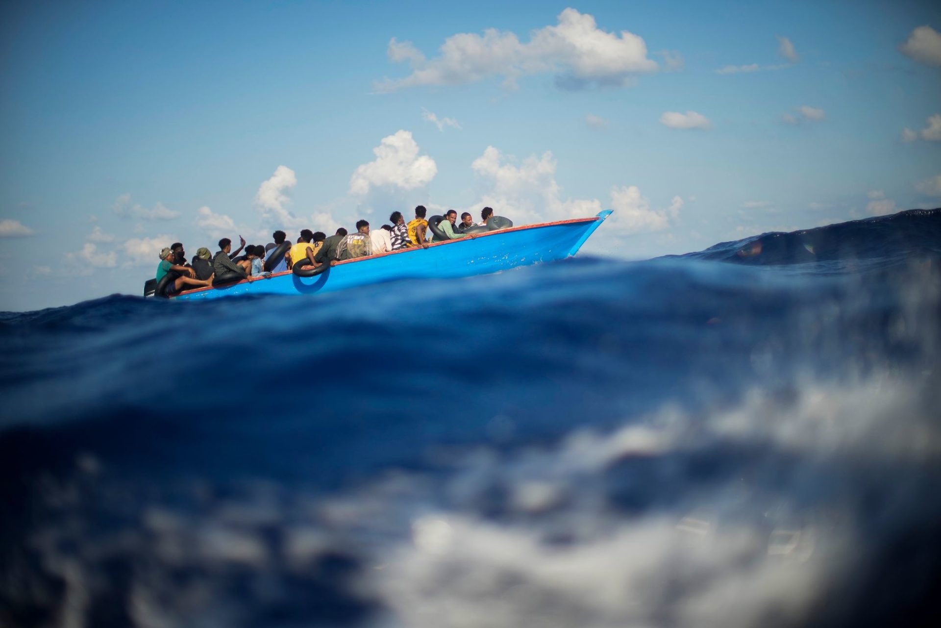Migranten sitzen in einem Holzboot südlich der italienischen Insel Lampedusa auf dem Mittelmeer. (zu dpa "Krisentreffen zu Migration: EU-Kommission fordert mehr Zusammenarbeit")