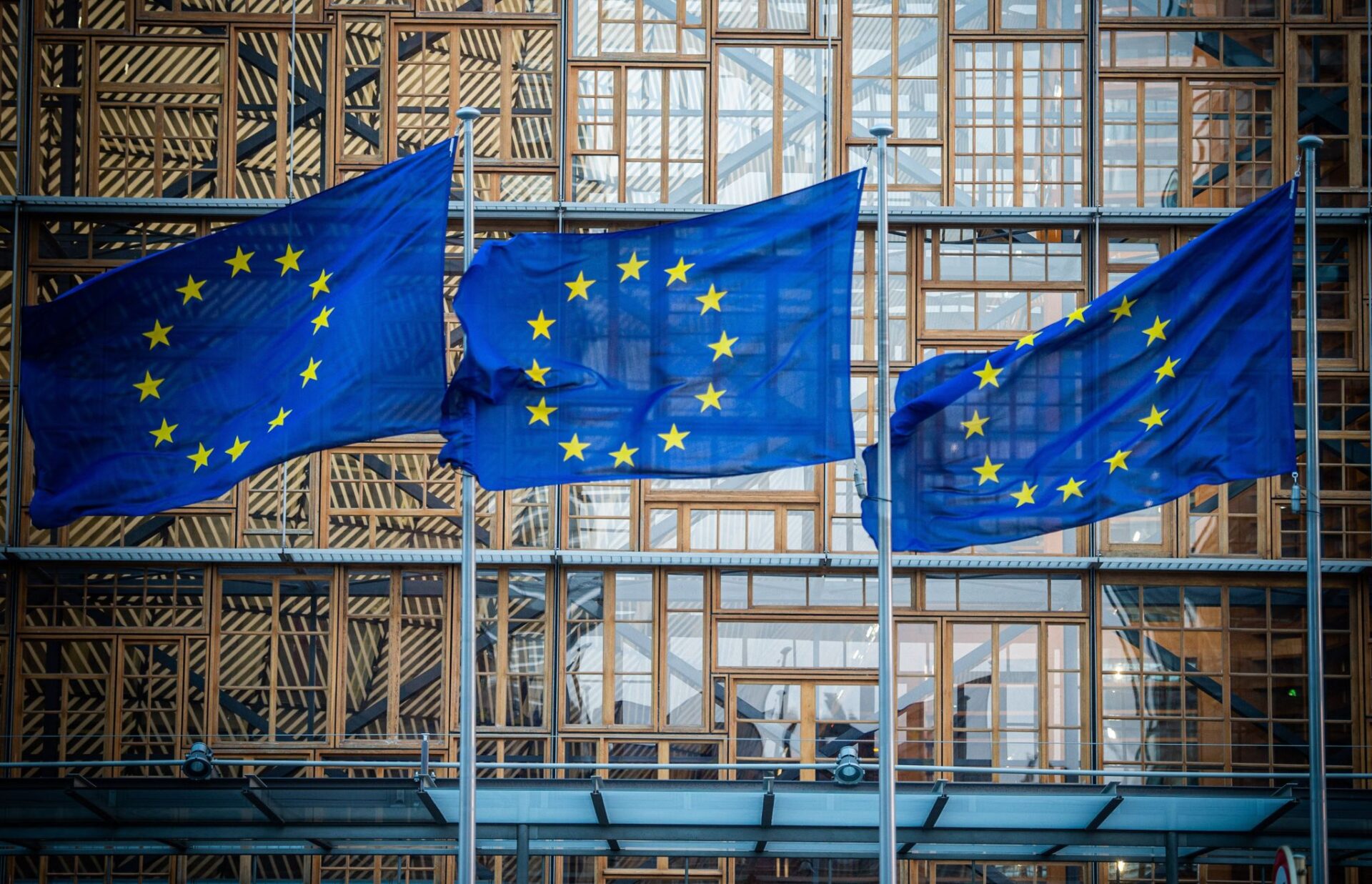 Flaggen der Europäischen Union wehen im Wind vor dem Europa-Gebäude. Die von der EU-Kommission geplanten neuen europäischen Schuldenregeln würden einer Untersuchung zufolge Investitionen in den Klimaschutz hemmen - und somit zu Wettbewerbsnachteilen führen. (zu dpa: «Analyse: EU-Schuldenregeln hemmen Investitionen in den Klimaschutz»)