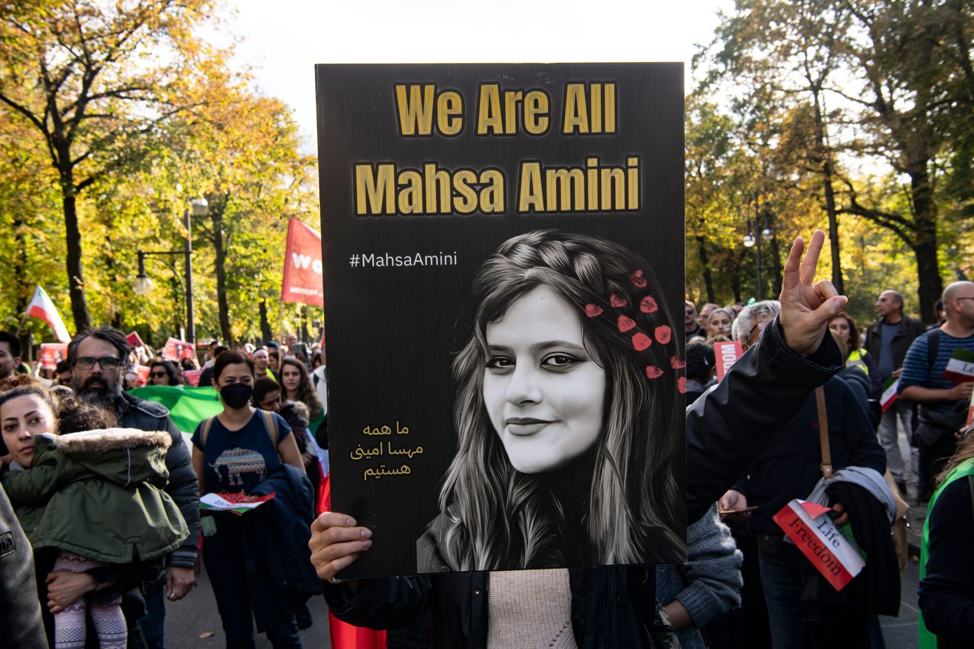 Ein Teilnehmer der Großdemonstration "Solidarität mit den Protestierenden im Iran" hält am Großen Stern ein Plakat mit der Aufschrift "We Are All Mahsa Amini".     (zu dpa "EU droht Iran zu Todestag von Amini mit weiteren Strafmaßnahmen")