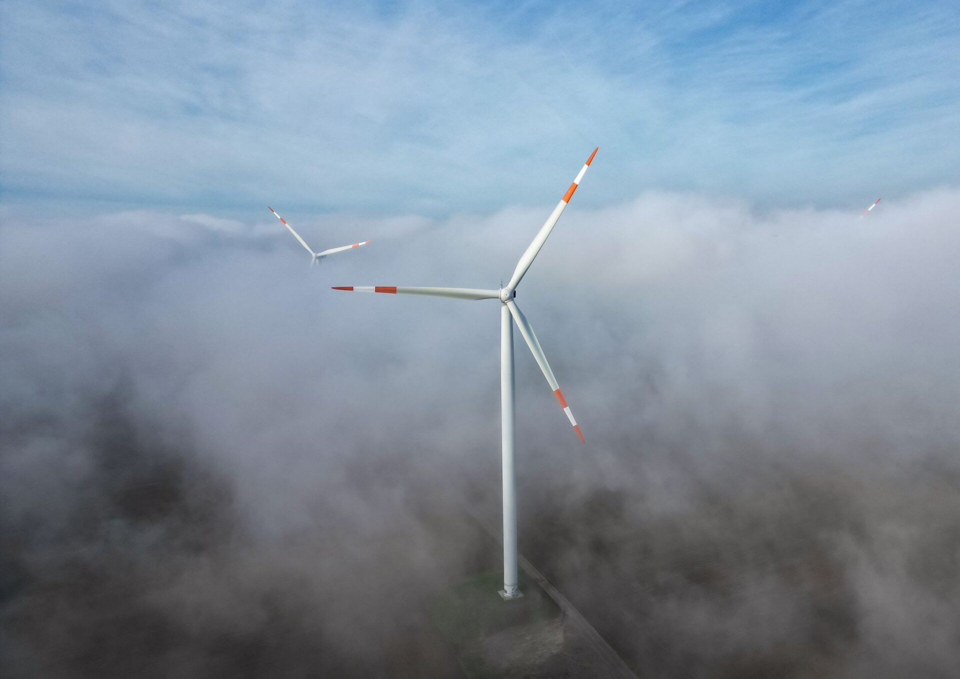 The wind turbines in a wind farm stand out of the morning fog. The European Commission presented on Tuesday new measures to boost the European wind power industry to reach the European Union's targets for renewable energy generation by 2030.
