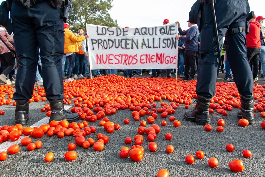 Varios agricultores han arrojado tomates durante una concentración el puerto de Motril (Granada) este miércoles, donde los manifestantes han cortado el acceso principal. EFE/Alba Feixas