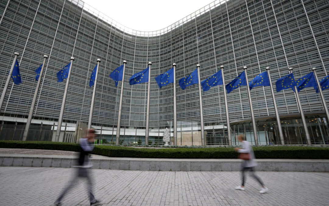 FILE - European Union flags flap in the wind as pedestrians walk by EU headquarters in Brussels, Sept. 20, 2023. European officials widened a ban on Meta’s “behavioral advertising” practices to most of Europe on Wednesday, Nov. 1, setting up a broader conflict between the continent’s privacy-conscious institutions and an American technology giant. (AP Photo/Virginia Mayo, File)