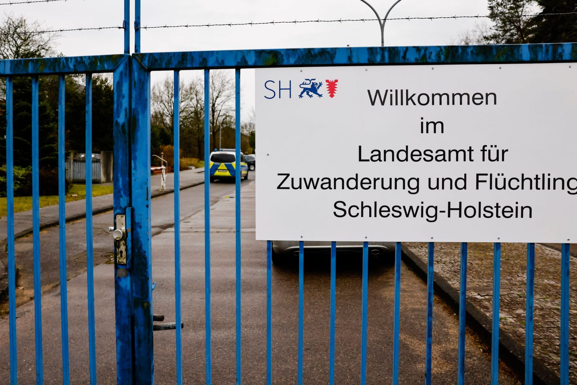 Ein Schild mit der Aufschrift «Willkommen im Landesamt für Zuwanderung und Flüchtline Schleswig-Holstein» ist an einem Zaun der Landesunterkunft der Gemeinde Seeth im Kreis Nordfriesland angebracht. (zu dpa: «Weniger Asylsuchende in Schleswig-Holstein»)