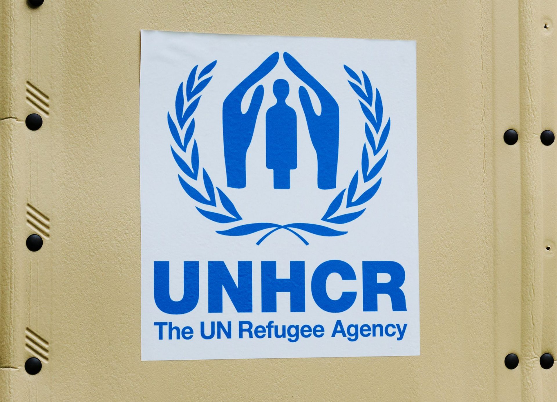 The UNHCR logo is placed on a self-build hut.