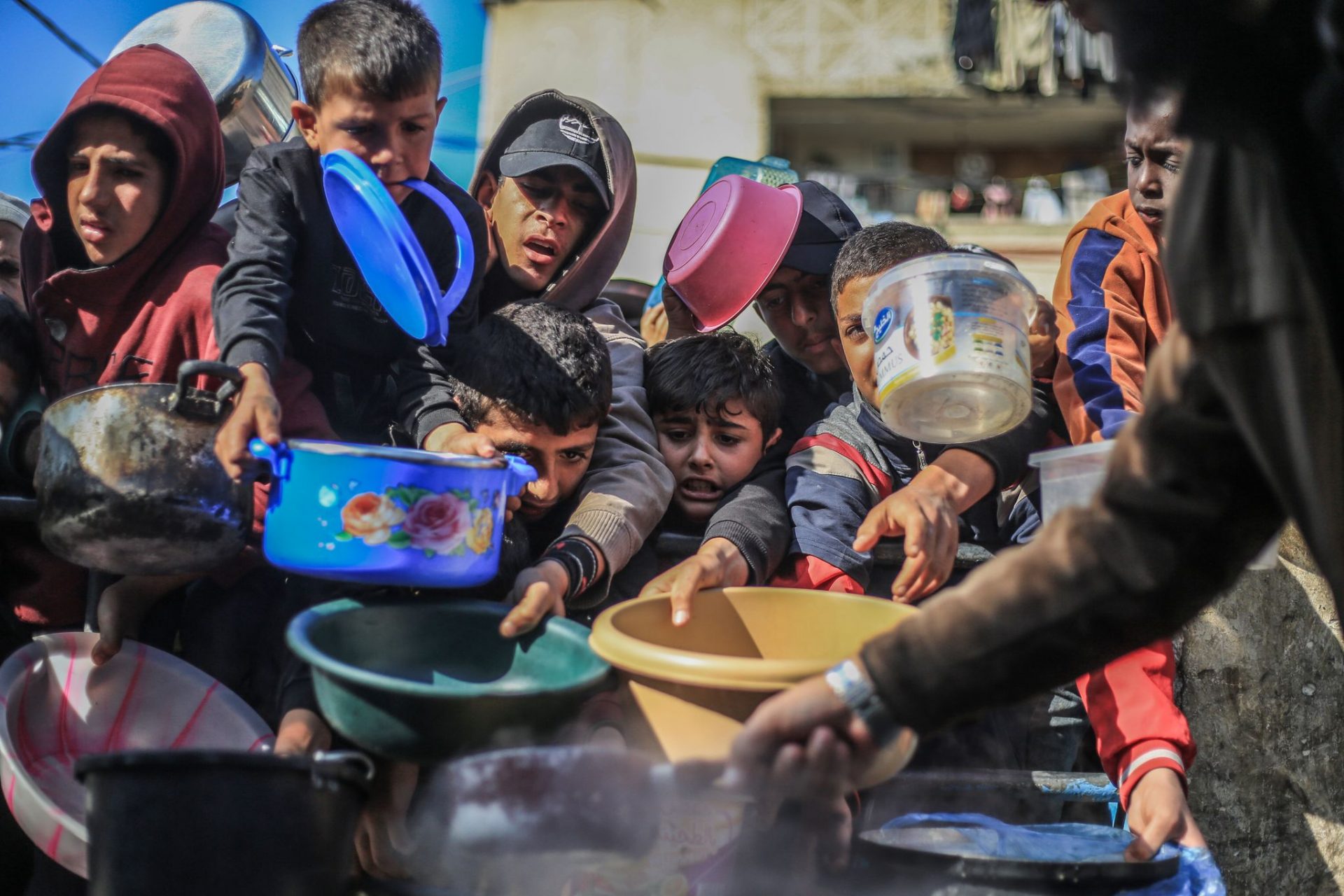 Palestinian children receive food prepared in a charity kitchen.