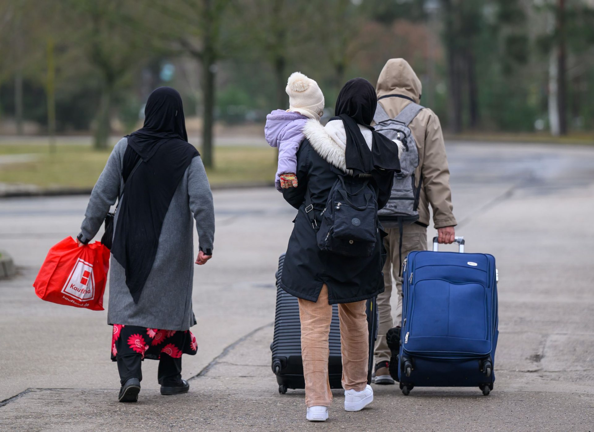 Migranten verlassen mit Reisegepäck das Gelände der Zentralen Ausländerbehörde Brandenburgs (ZABH). Brandenburg geht einen neuen Weg für schnellere Rückführungen von Asylbewerbern nach Polen. Ein neues sogenanntes «Dublin-Zentrum» für eine schnellere Rückführung von Asylsuchenden in andere EU-Staaten nimmt die Arbeit auf. Dort sollen Überstellungen nach Polen beschleunigt organisiert werden. Es geht um sogenannte Dublin-Fälle, also um Menschen, die ihr Asylverfahren in einem anderen EU-Staat durchlaufen müssen.