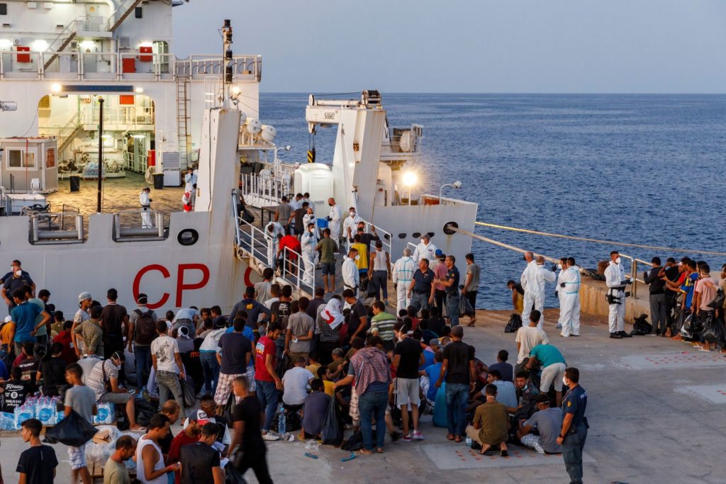 Migranten warten an Bord eines Schiffes der italienischen Küstenwache auf der sizilianischen Insel Lampedusa. Foto: David Lohmueller